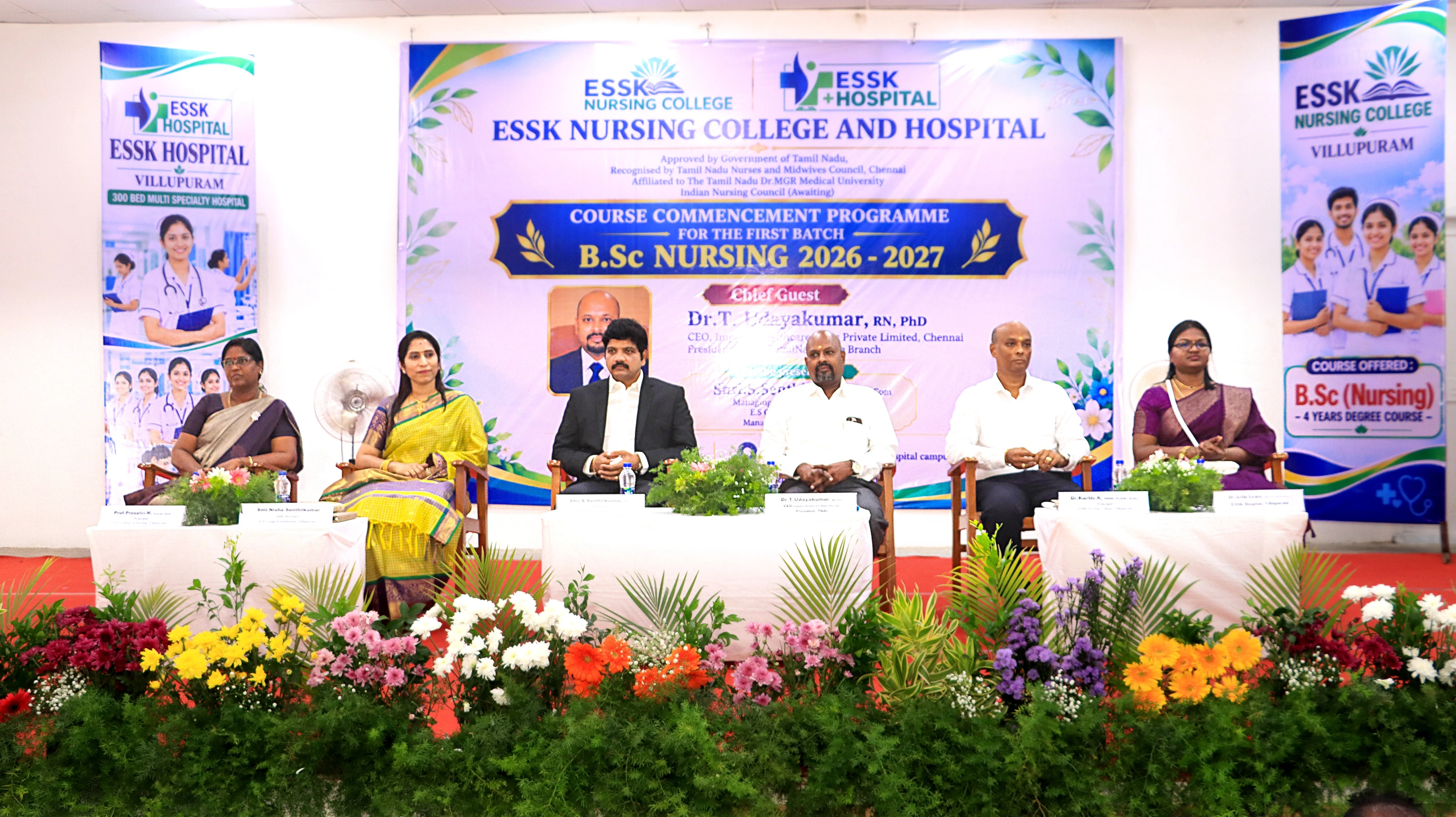 Guests and college staff seated on a stage decorated with flowers, under a banner for the Course Commencement Programme, B.Sc Nursing 2026–2027